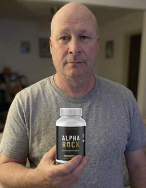 An AlphaRock customer holding a bottle of the male performance support capsules