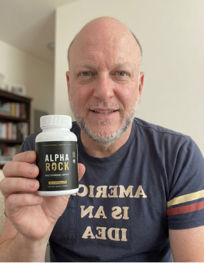 An AlphaRock customer holding a bottle of the male performance support capsules